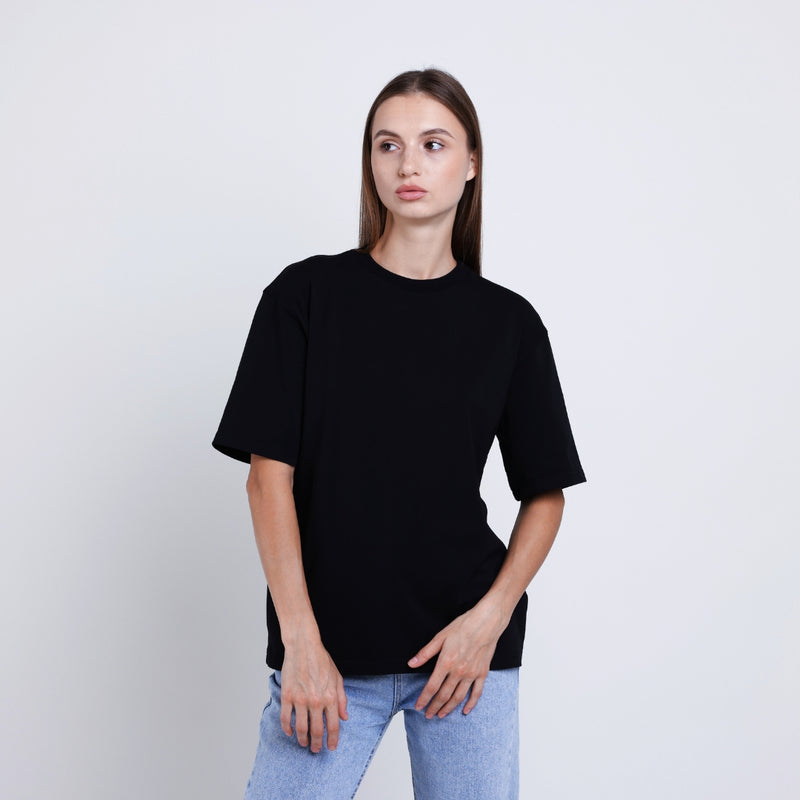 A woman wearing a minimalist oversized black tshirt for a modern casual style.