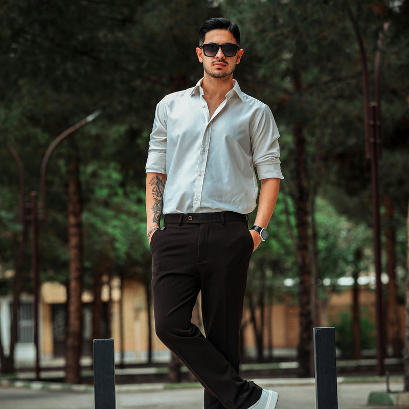 A man wearing a light button down shirt and trousers for a stylish mens smart casual outfit.